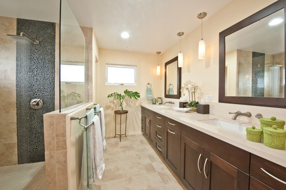 Inspiration for a mid-sized transitional master bathroom in Hawaii with an undermount sink, shaker cabinets, solid surface benchtops, an open shower, beige tile, beige walls, travertine floors, dark wood cabinets, beige floor and an open shower.