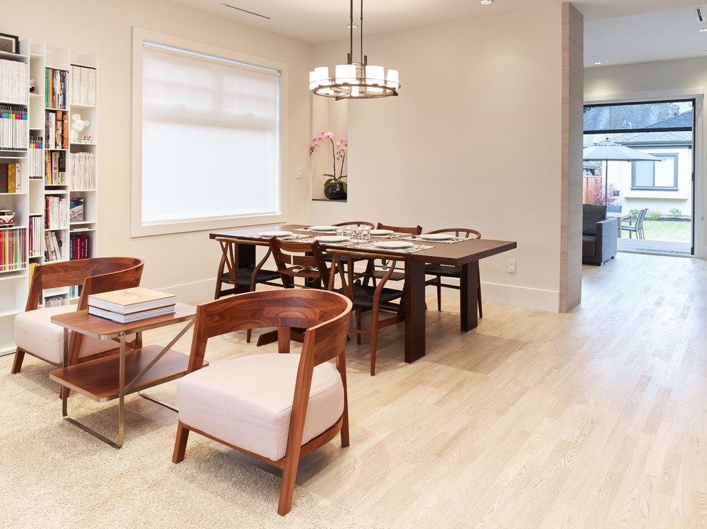 This is an example of a small contemporary dining room in Vancouver with beige walls, light hardwood floors and no fireplace.
