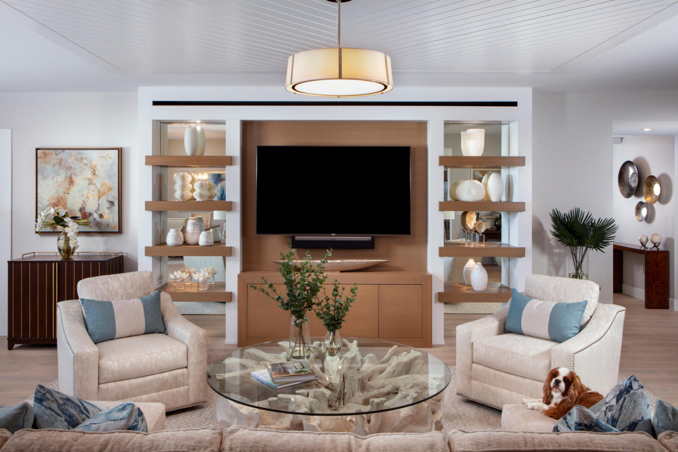This is an example of a large beach style open concept family room in Miami with grey walls, light hardwood floors, a built-in media wall, brown floor and timber.