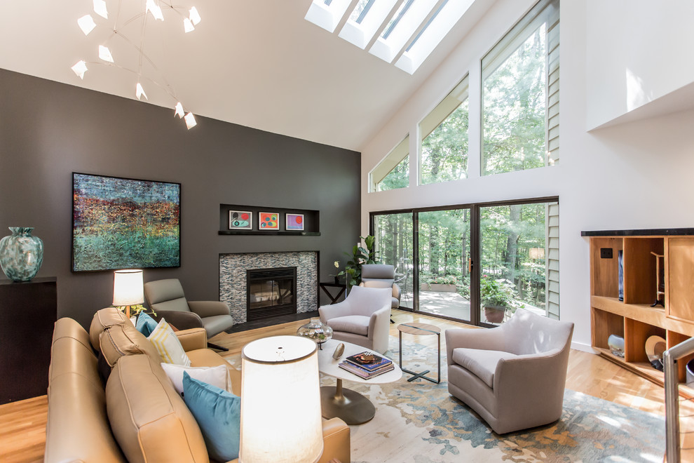 Photo of a mid-sized midcentury open concept family room in DC Metro with white walls, light hardwood floors, a standard fireplace, a tile fireplace surround, a concealed tv and yellow floor.