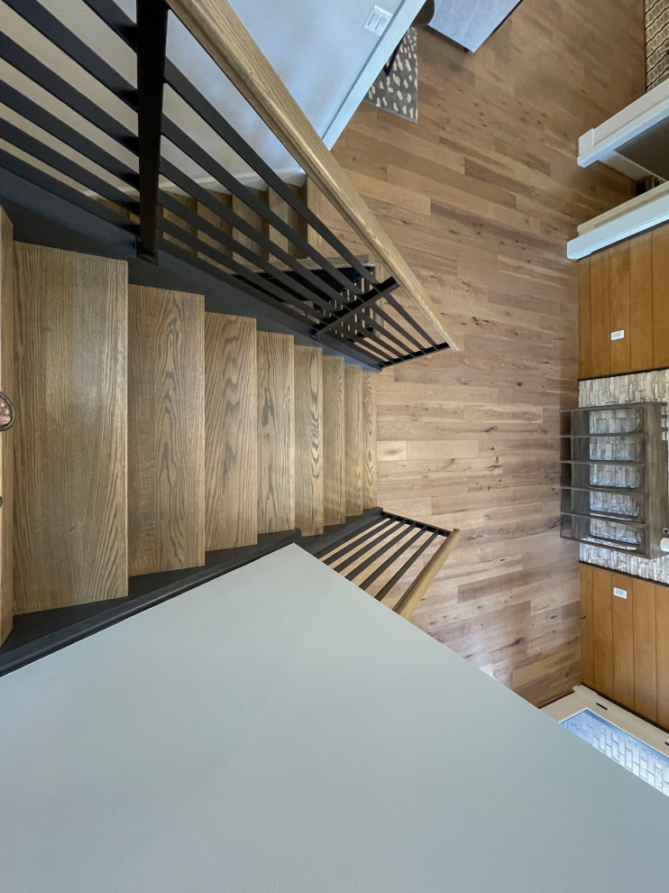 Large contemporary wood straight mixed railing staircase in DC Metro with panelled walls.