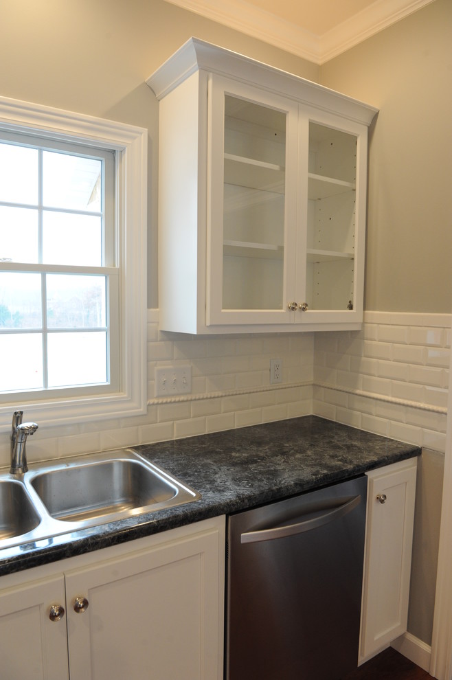 Eat-in kitchen - transitional u-shaped eat-in kitchen idea in Chicago with a drop-in sink, flat-panel cabinets, white cabinets, laminate countertops, white backsplash and subway tile backsplash