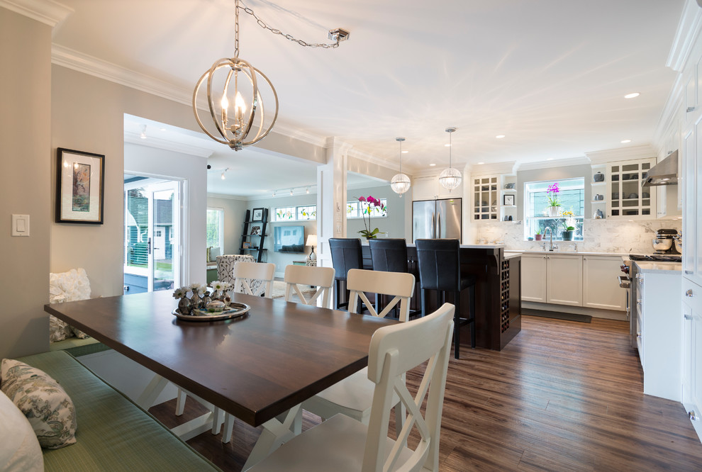 Open concept kitchen - mid-sized transitional l-shaped medium tone wood floor open concept kitchen idea in Vancouver with an undermount sink, shaker cabinets, white cabinets, quartz countertops, white backsplash, stone tile backsplash, stainless steel appliances and an island