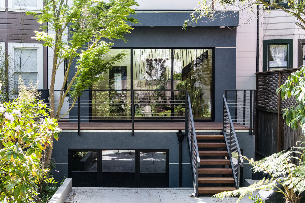 Idée de décoration pour une façade de maison bleue minimaliste en stuc et bardage à clin de taille moyenne et à deux étages et plus avec un toit plat.