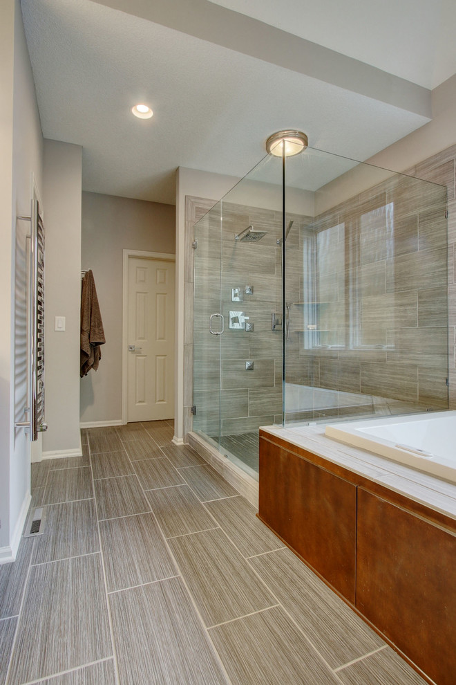 Design ideas for a mid-sized modern master bathroom in Kansas City with flat-panel cabinets, medium wood cabinets, a drop-in tub, a corner shower, gray tile, ceramic tile, grey walls, ceramic floors, an undermount sink and engineered quartz benchtops.