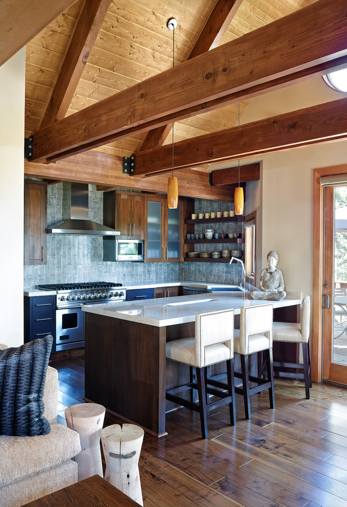 Open concept kitchen - mid-sized transitional u-shaped dark wood floor and brown floor open concept kitchen idea with gray backsplash, a farmhouse sink, open cabinets, dark wood cabinets, solid surface countertops, ceramic backsplash, stainless steel appliances and a peninsula