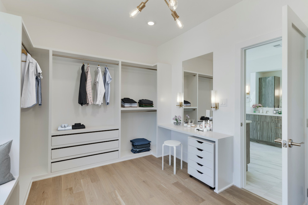 Diseño de armario y vestidor unisex minimalista de tamaño medio con a medida y suelo de madera en tonos medios