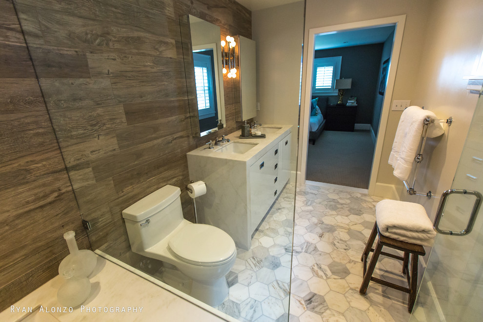 This is an example of a large contemporary master bathroom in Orange County with an undermount sink, flat-panel cabinets, white cabinets, marble benchtops, an undermount tub, a curbless shower, a one-piece toilet, brown tile, porcelain tile and marble floors.