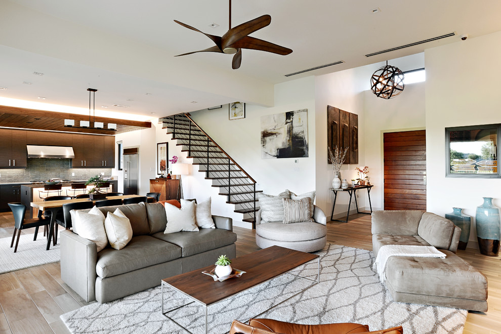 Photo of a contemporary open concept living room in Dallas with white walls and light hardwood floors.