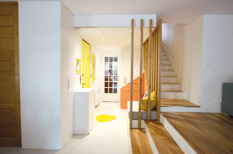 This is an example of a large scandinavian foyer in Paris with white walls, concrete floors, a single front door, a yellow front door and grey floor.