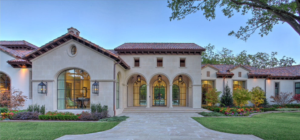 Design ideas for an expansive mediterranean two-storey stucco beige house exterior in Dallas with a gable roof and a tile roof.