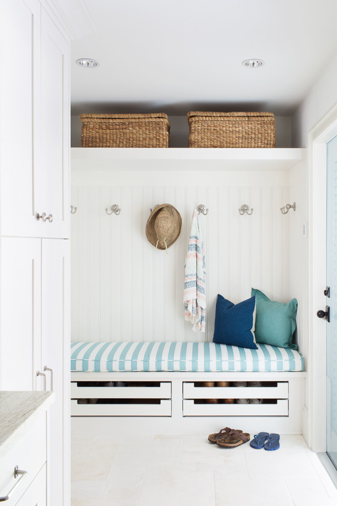 Inspiration for a mid-sized coastal l-shaped marble floor and white floor mudroom remodel in Miami with an undermount sink, beaded inset cabinets, white cabinets, marble countertops, white walls and a stacked washer/dryer