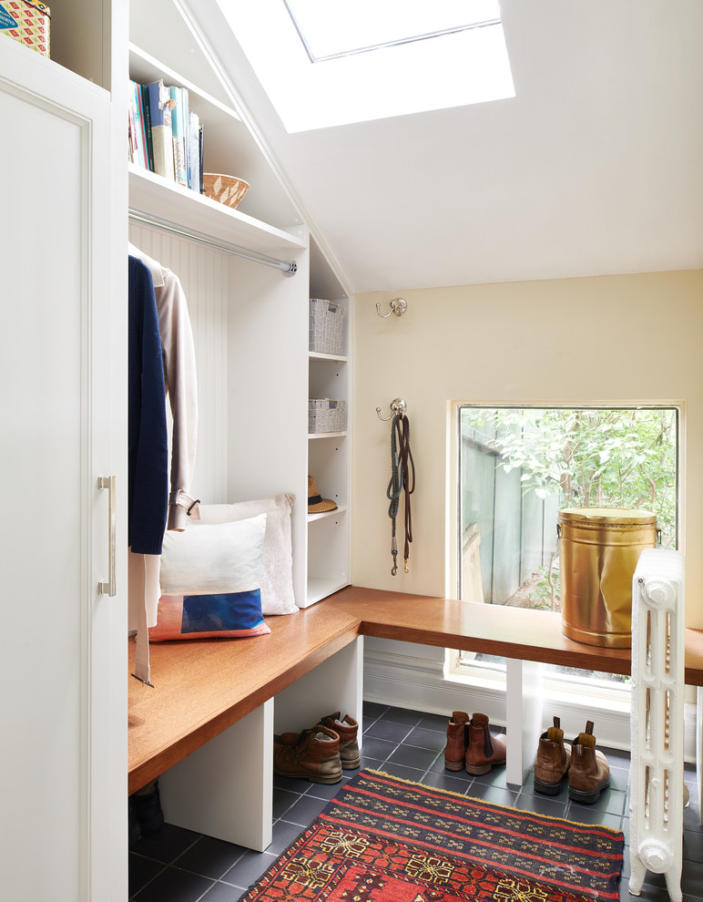 This is an example of a mid-sized eclectic mudroom in Toronto with beige walls, ceramic floors, a single front door, a white front door and black floor.