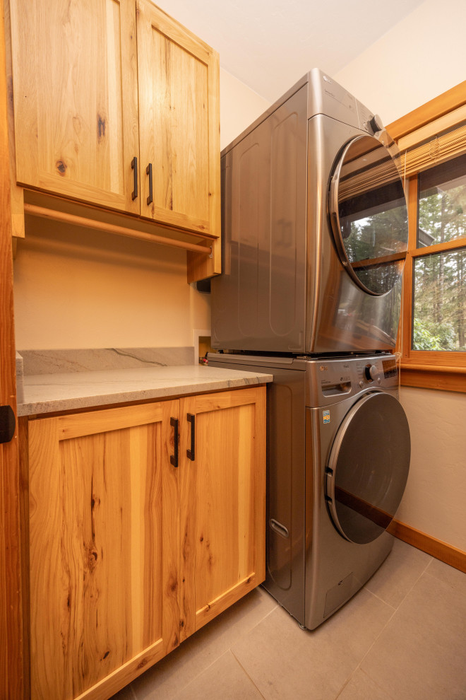 Inspiration for a small rustic porcelain tile and gray floor laundry room remodel with shaker cabinets, quartzite countertops, beige walls, a stacked washer/dryer and gray countertops