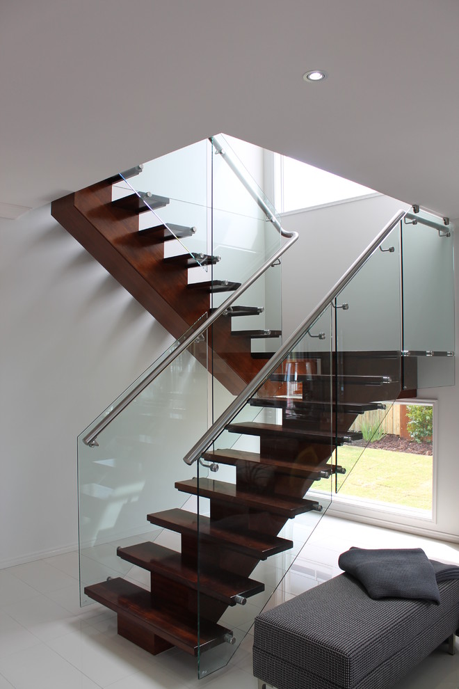 Inspiration for a contemporary wood u-shaped staircase in Brisbane with open risers and glass railing.