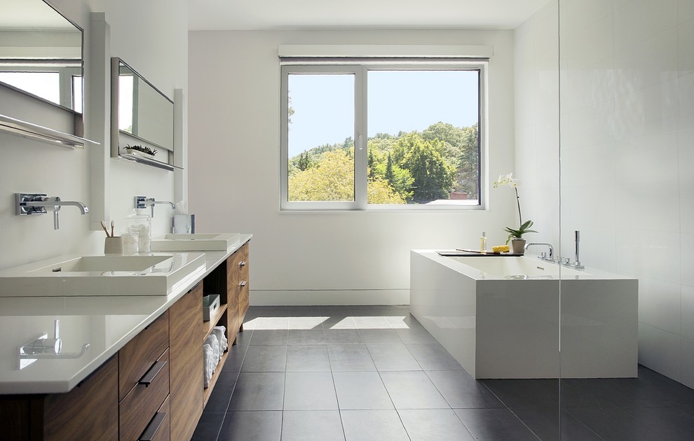 Inspiration for a large modern master bathroom in Boston with flat-panel cabinets, dark wood cabinets, a freestanding tub, an open shower, white walls, ceramic floors, a drop-in sink, engineered quartz benchtops, grey floor, an open shower and white benchtops.