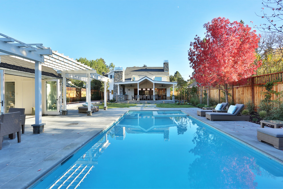 Inspiration for a mid-sized transitional backyard rectangular pool in Denver with natural stone pavers and a hot tub.