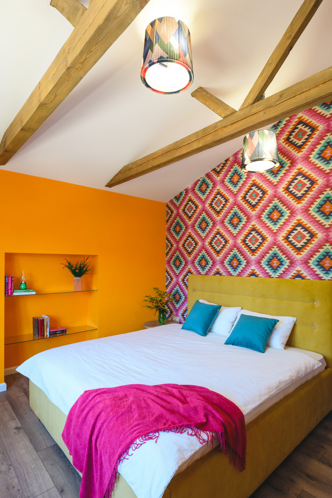 Cette photo montre une petite chambre d'amis tendance avec sol en stratifié, aucune cheminée, un sol marron, poutres apparentes, un plafond voûté, du papier peint et un mur multicolore.