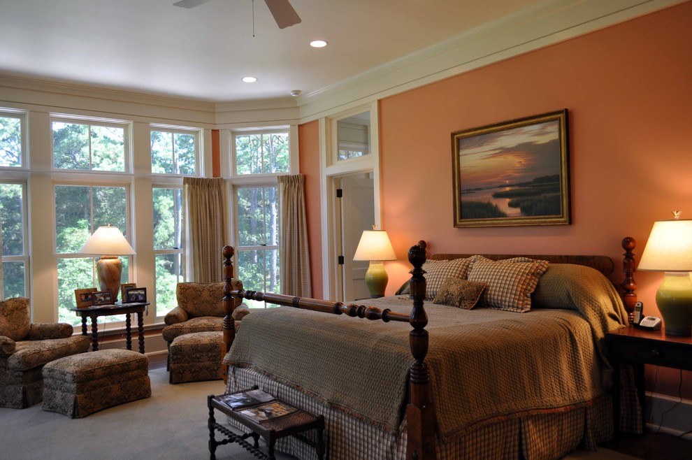This is an example of a traditional bedroom in Atlanta with orange walls and carpet.