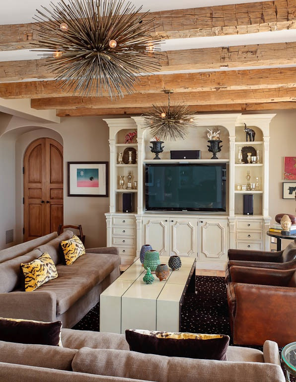 Mediterranean family room in Los Angeles with beige walls, limestone floors, a built-in media wall and beige floor.