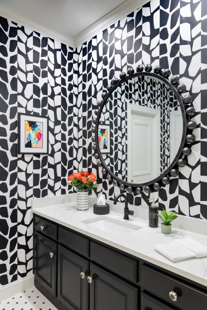 Photo of a transitional powder room in Dallas with black cabinets, multi-coloured walls, white benchtops, a built-in vanity, wallpaper, a drop-in sink and multi-coloured floor.