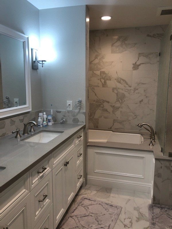 This is an example of a large midcentury master bathroom in Orange County with beaded inset cabinets, white cabinets, a drop-in tub, an alcove shower, multi-coloured tile, marble, grey walls, marble floors, a drop-in sink, quartzite benchtops, multi-coloured floor, a hinged shower door, grey benchtops, an enclosed toilet, a double vanity and a built-in vanity.