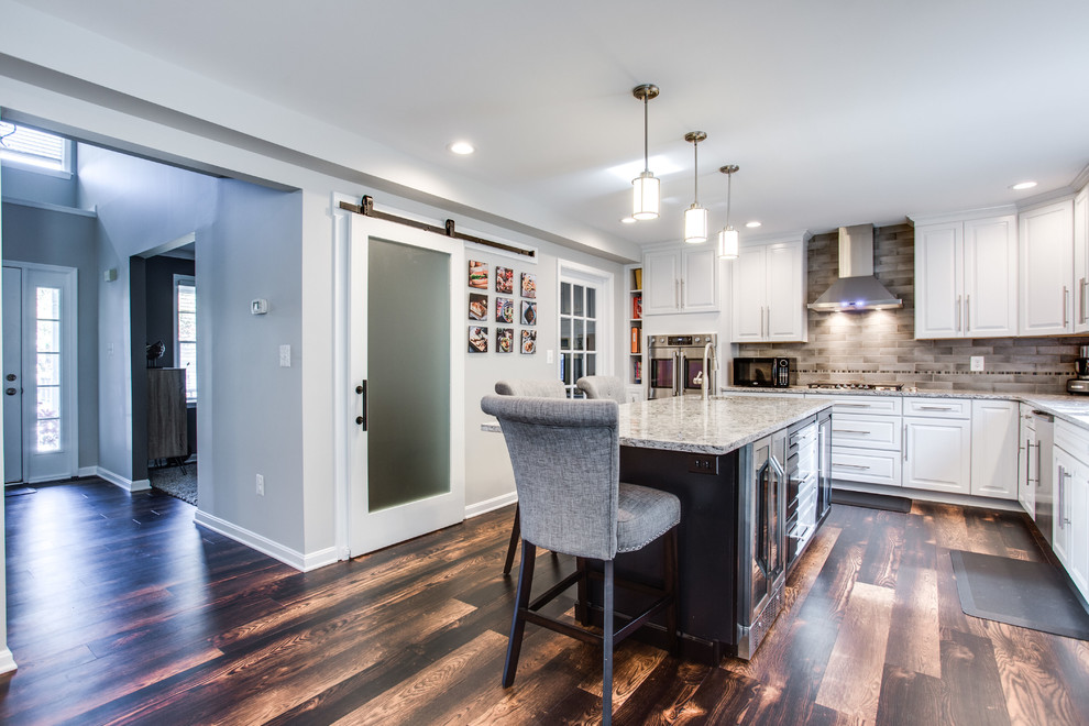 Large traditional u-shaped kitchen in DC Metro with an undermount sink, raised-panel cabinets, quartz benchtops, stainless steel appliances, dark hardwood floors and with island.