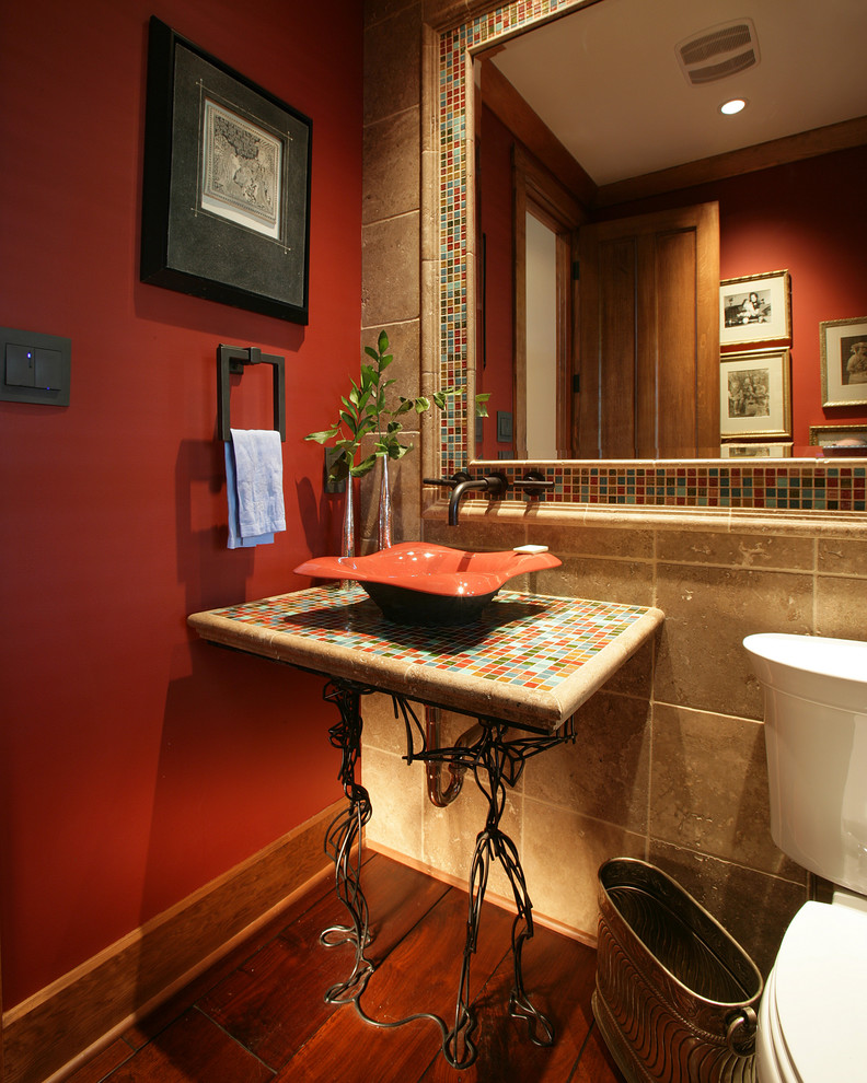 Small traditional powder room in Other with a two-piece toilet, blue tile, green tile, orange tile, red tile, beige tile, multi-coloured tile, mosaic tile, red walls, dark hardwood floors, a vessel sink and tile benchtops.