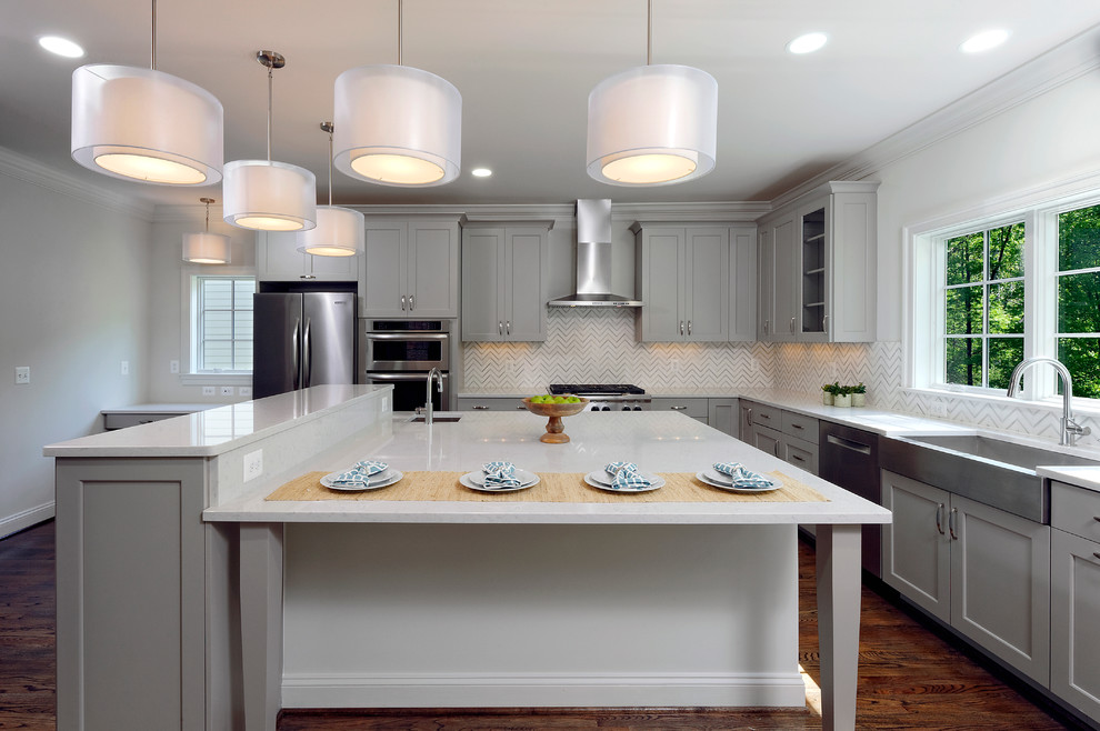 This is an example of a large arts and crafts l-shaped open plan kitchen in DC Metro with a farmhouse sink, shaker cabinets, grey cabinets, granite benchtops, white splashback, ceramic splashback, stainless steel appliances, dark hardwood floors and with island.