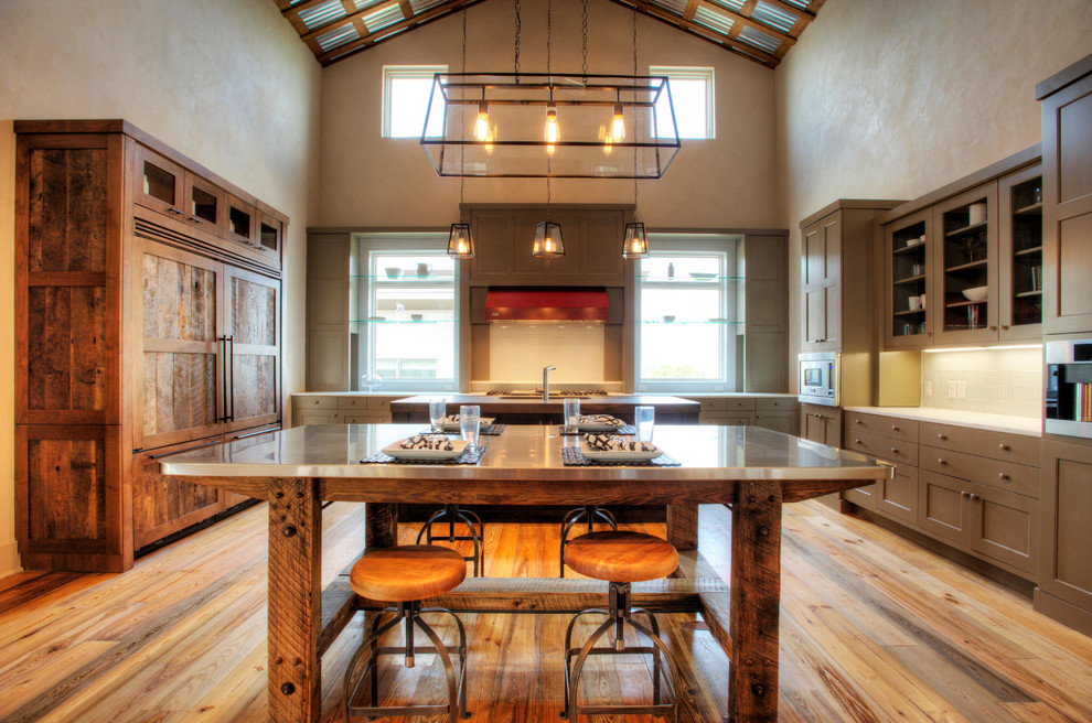 Photo of a country kitchen in Austin with shaker cabinets, stainless steel benchtops and panelled appliances.