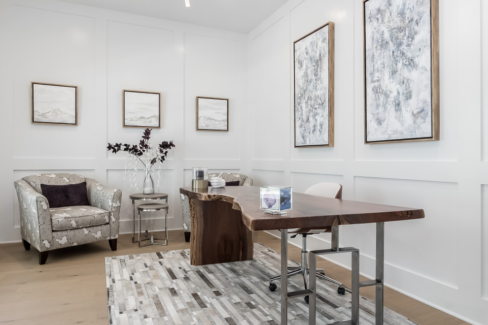 コロンバスにある高級な広いトランジショナルスタイルのおしゃれな書斎 (白い壁、淡色無垢フローリング、自立型机、ベージュの床、パネル壁、暖炉なし) の写真