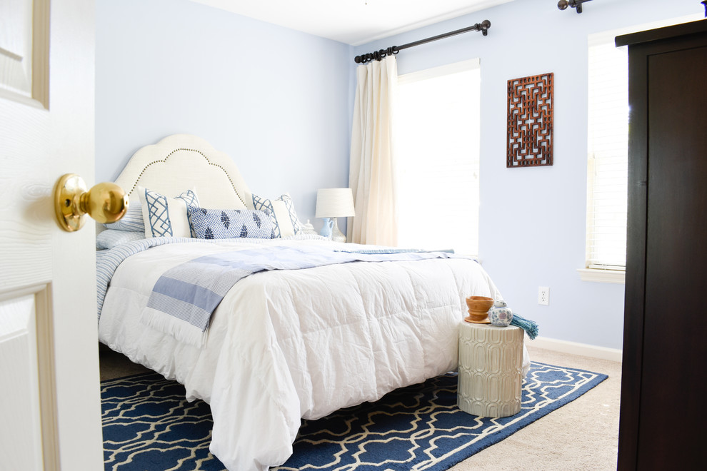 This is an example of a mid-sized transitional guest bedroom in Nashville with blue walls, carpet and beige floor.
