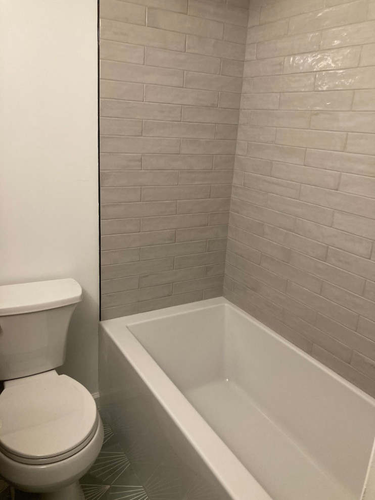 Small modern bathroom in DC Metro with recessed-panel cabinets, grey cabinets, an alcove tub, an alcove shower, a two-piece toilet, gray tile, porcelain tile, white walls, cement tiles, an undermount sink, quartzite benchtops, grey floor, a shower curtain, white benchtops, a single vanity and a built-in vanity.