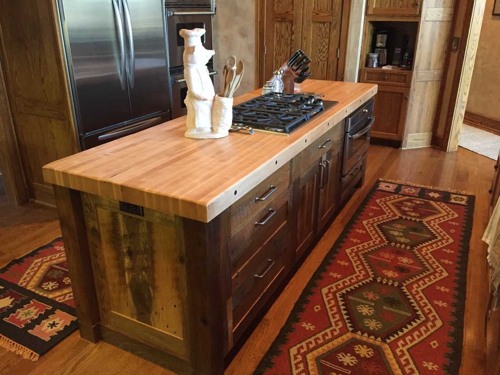 Example of a mountain style kitchen design in Denver with shaker cabinets, distressed cabinets, wood countertops and an island