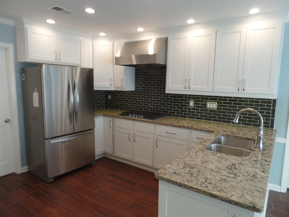 This is an example of a large transitional u-shaped eat-in kitchen in Nashville with an undermount sink, shaker cabinets, white cabinets, quartz benchtops, green splashback, glass tile splashback, stainless steel appliances, porcelain floors and a peninsula.