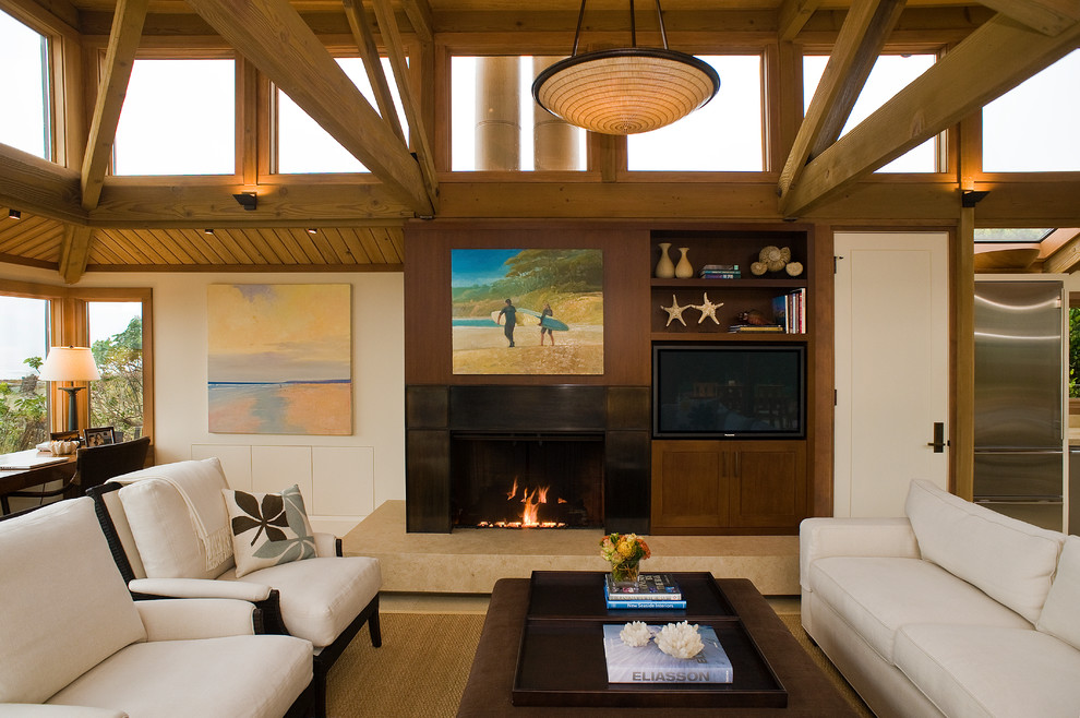 This is an example of a beach style open concept family room in San Francisco with beige walls, a standard fireplace and a built-in media wall.