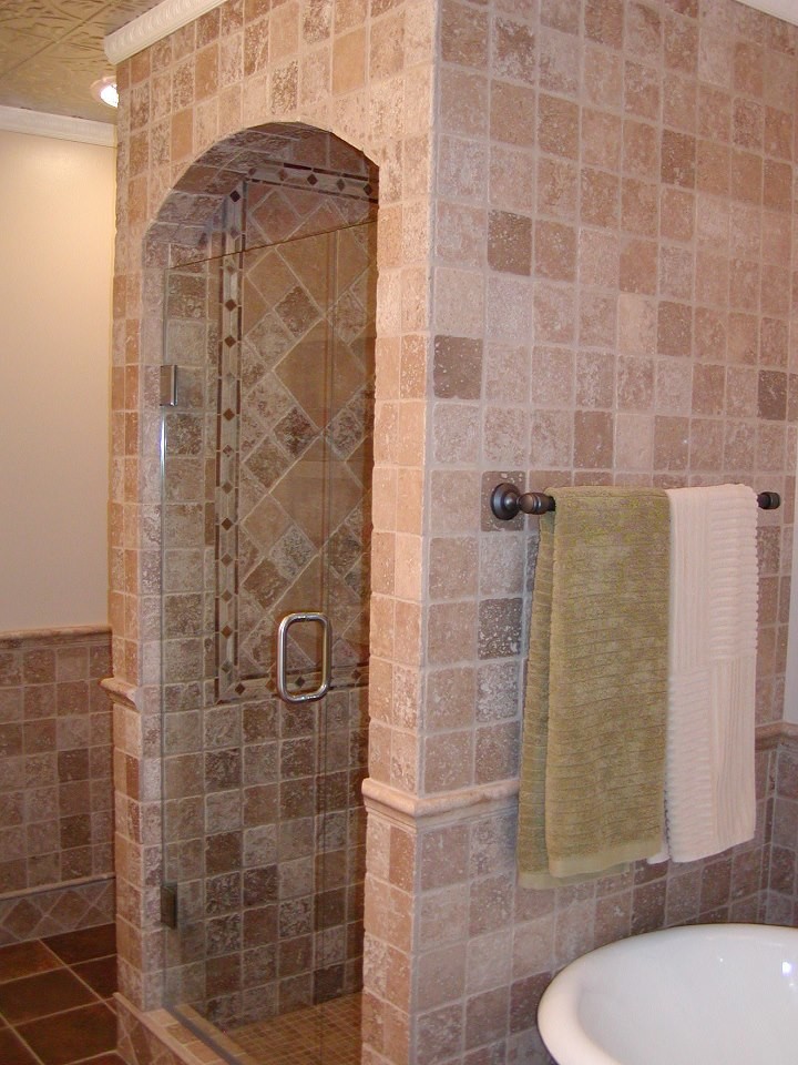 Freestanding bathtub - large traditional master brown tile, stone tile and beige tile porcelain tile and brown floor freestanding bathtub idea in Minneapolis with a hinged shower door and beige walls
