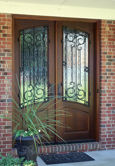 This is an example of a mid-sized country front door in Tampa with red walls, brick floors, a double front door and a dark wood front door.