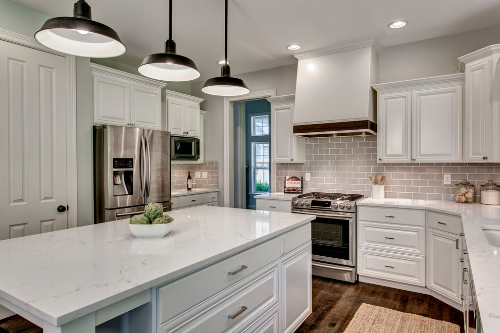 Inspiration for a large transitional u-shaped dark wood floor and brown floor eat-in kitchen remodel in Seattle with an undermount sink, raised-panel cabinets, white cabinets, marble countertops, gray backsplash, ceramic backsplash, stainless steel appliances and an island