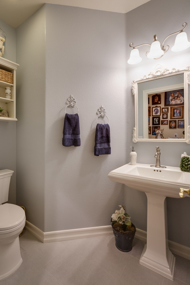 Photo of a small transitional powder room in San Diego with grey walls, porcelain floors and a pedestal sink.