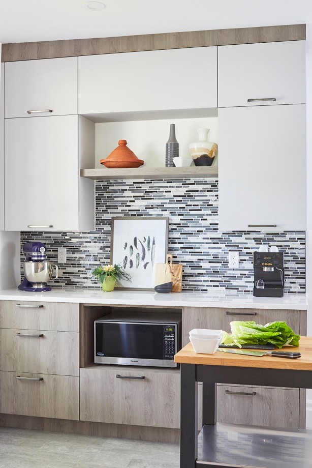 Mid-sized eclectic l-shaped eat-in kitchen in Toronto with a double-bowl sink, flat-panel cabinets, white cabinets, granite benchtops, blue splashback, glass tile splashback, stainless steel appliances, with island and white benchtop.