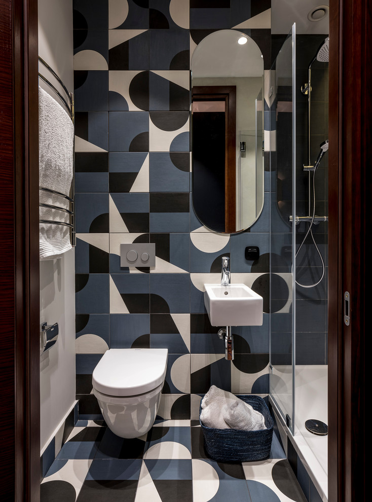 This is an example of a contemporary 3/4 bathroom in Moscow with an alcove shower, a wall-mount toilet, multi-coloured tile, a wall-mount sink and multi-coloured floor.