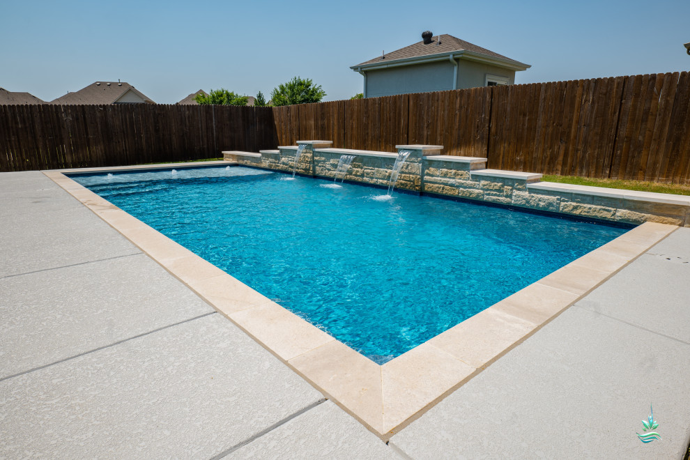 На фото: спортивный, прямоугольный ландшафтный бассейн среднего размера на заднем дворе в стиле кантри с покрытием из бетонных плит с