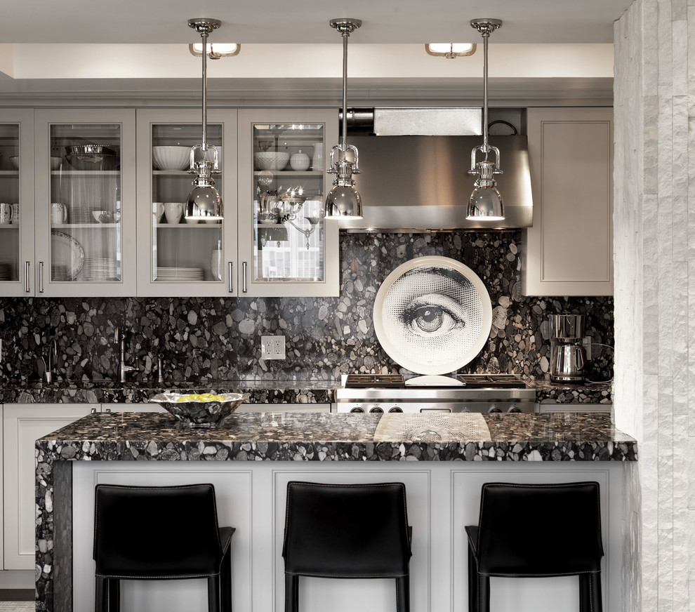 This is an example of a contemporary kitchen in New York with glass-front cabinets, grey cabinets, black splashback and stone slab splashback.