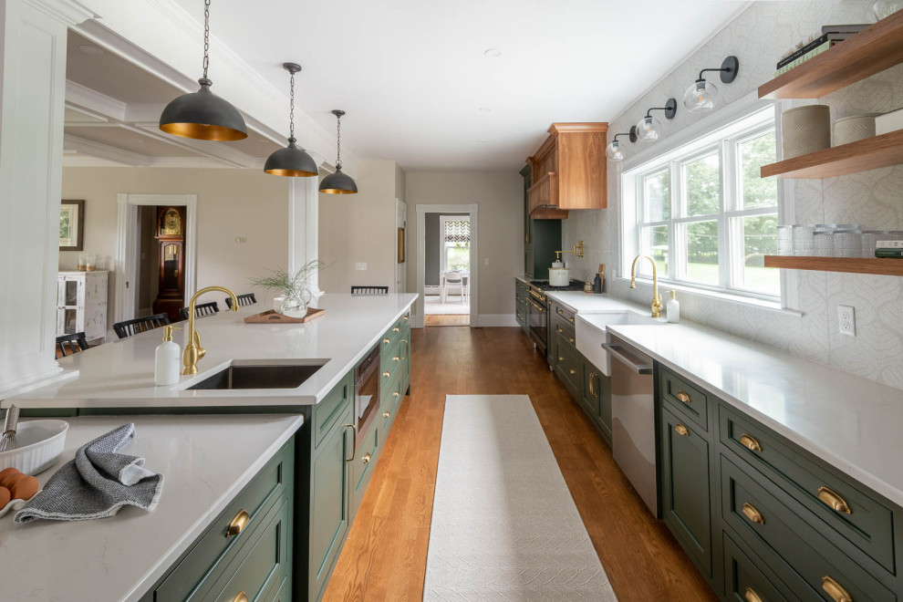 Eat-in kitchen - huge transitional medium tone wood floor and brown floor eat-in kitchen idea in Boston with a farmhouse sink, shaker cabinets, green cabinets, quartz countertops, beige backsplash, an island and white countertops