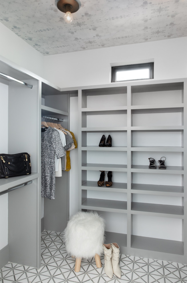 Modern women's storage and wardrobe in Austin with marble floors and wallpaper.