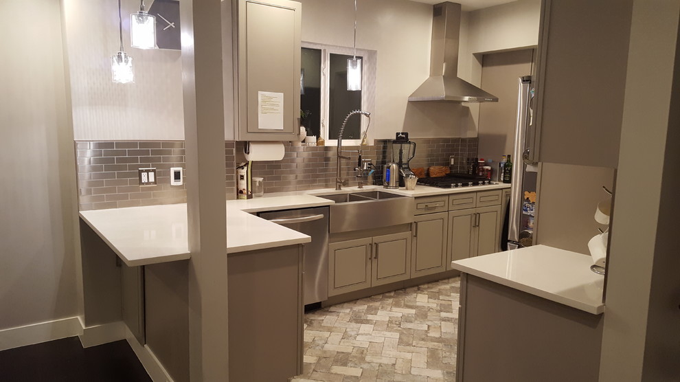 Photo of a mid-sized modern kitchen in Denver with a farmhouse sink, grey cabinets, metallic splashback, metal splashback, stainless steel appliances, brick floors and grey floor.