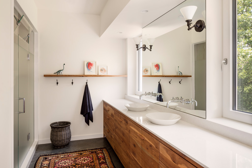 This is an example of a contemporary bathroom in Other with flat-panel cabinets, medium wood cabinets, a corner shower, white walls, concrete floors, a vessel sink, grey floor, a hinged shower door and white benchtops.