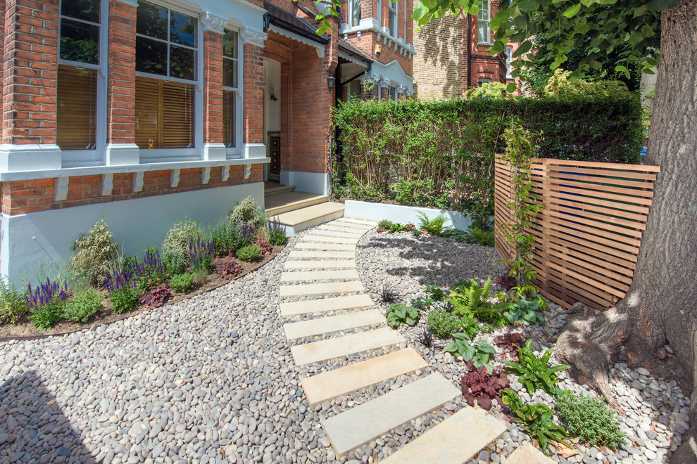 Design ideas for a small contemporary front yard formal garden in London with a garden path and gravel.