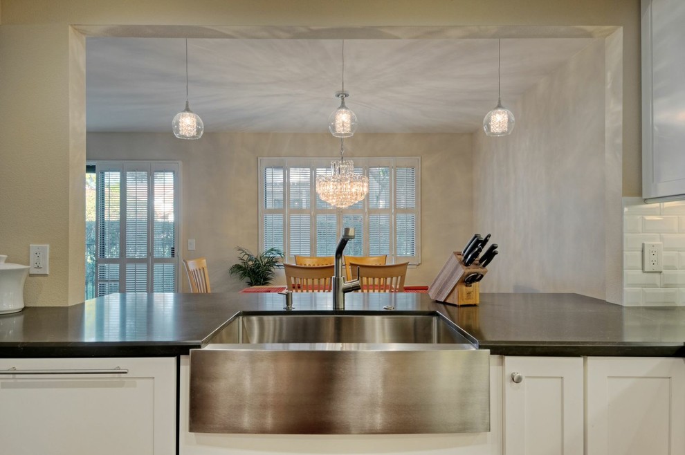 Inspiration for a mid-sized transitional galley medium tone wood floor open concept kitchen remodel with a farmhouse sink, shaker cabinets, white cabinets, quartz countertops, white backsplash, ceramic backsplash, stainless steel appliances and no island